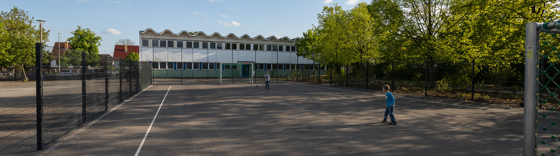 Fußballplatz mit zwei spielenden Kindern